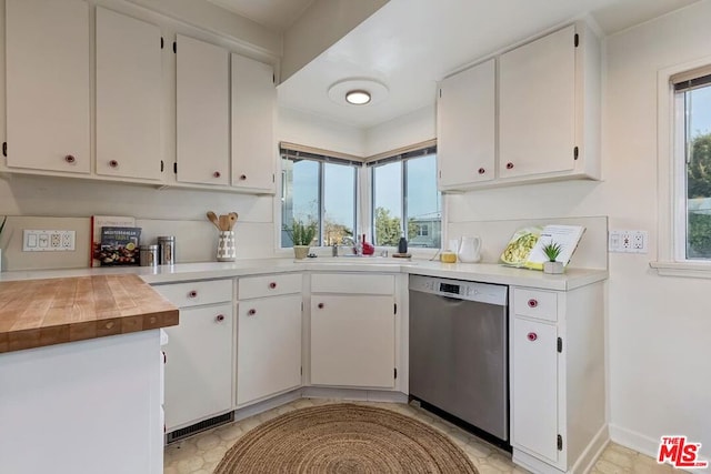 kitchen with white cabinetry, a wealth of natural light, and stainless steel dishwasher