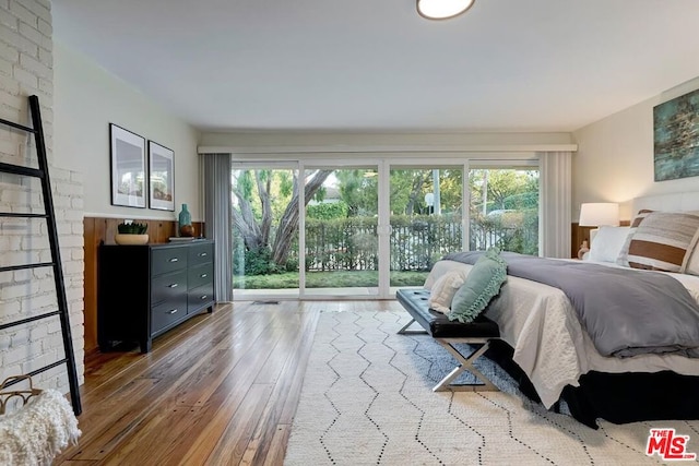 bedroom with multiple windows, hardwood / wood-style flooring, and access to exterior