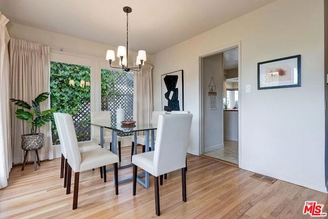 dining area featuring an inviting chandelier and light wood-type flooring