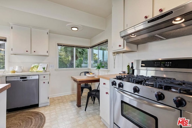 kitchen with extractor fan, stainless steel appliances, and white cabinets