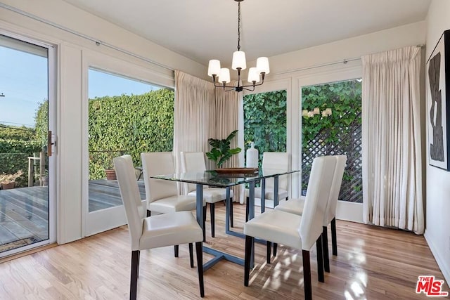 dining area with an inviting chandelier and light hardwood / wood-style floors