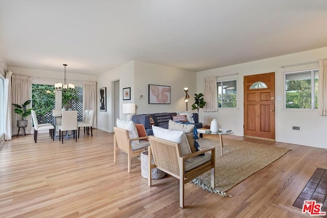 living room with light hardwood / wood-style floors and a chandelier