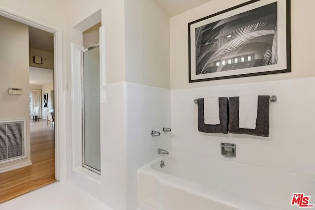 bathroom with a bath and wood-type flooring