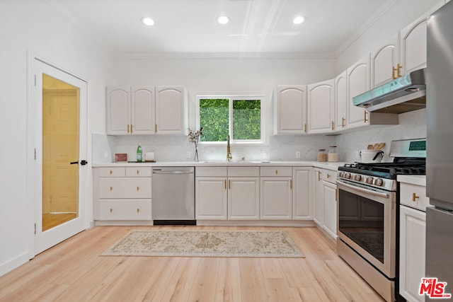 kitchen with stainless steel appliances, white cabinetry, sink, and light hardwood / wood-style flooring