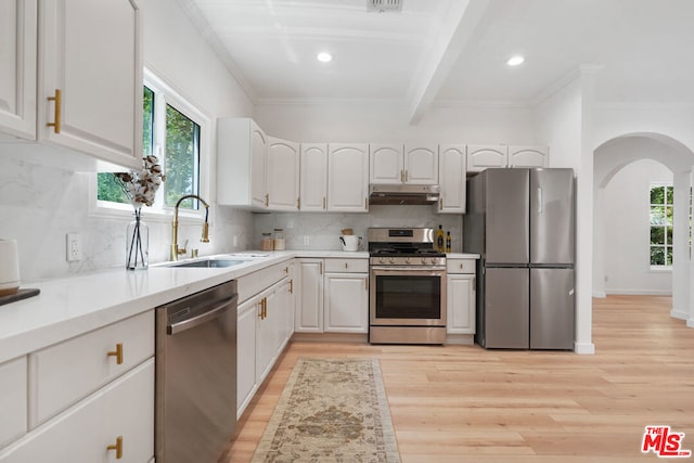 kitchen featuring sink, white cabinets, stainless steel appliances, crown molding, and light hardwood / wood-style flooring