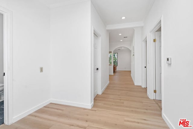 corridor featuring crown molding and light hardwood / wood-style flooring