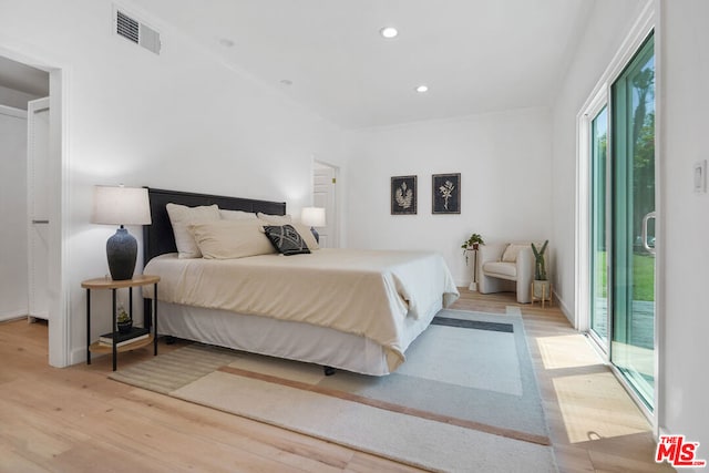 bedroom featuring access to exterior and light hardwood / wood-style flooring