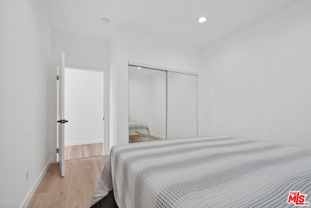 bedroom with a closet and light hardwood / wood-style flooring