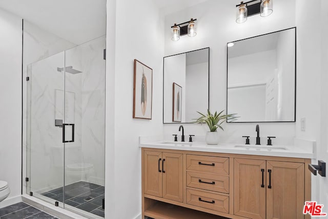 bathroom featuring vanity, a shower with shower door, and toilet