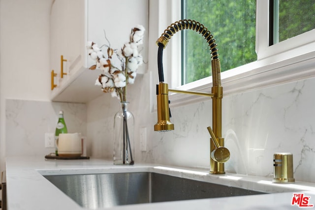 interior details featuring sink and backsplash