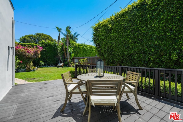 wooden terrace featuring a yard