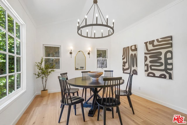 dining room with vaulted ceiling, ornamental molding, and light hardwood / wood-style floors