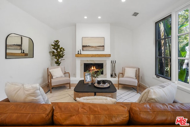 living room featuring a high end fireplace and light hardwood / wood-style flooring