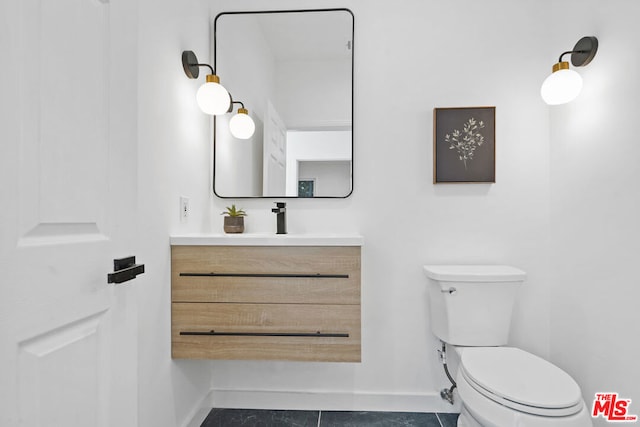 bathroom featuring vanity, tile patterned floors, and toilet