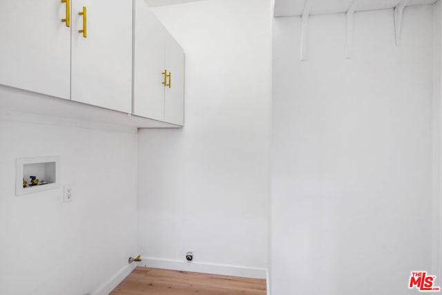 washroom featuring cabinets, washer hookup, hookup for a gas dryer, and light wood-type flooring