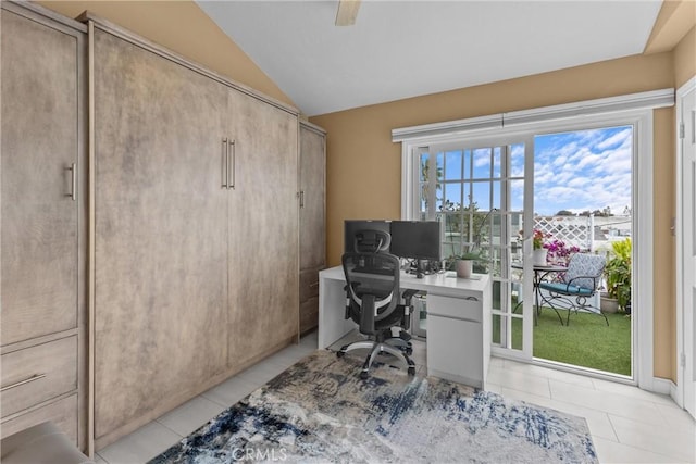 tiled office space featuring vaulted ceiling