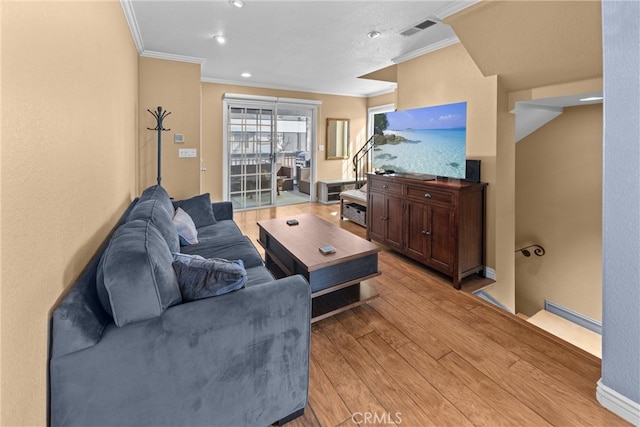 living room featuring ornamental molding and light hardwood / wood-style floors