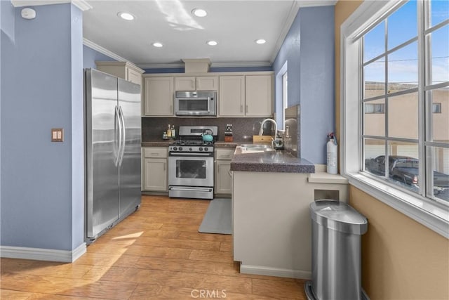 kitchen featuring appliances with stainless steel finishes, sink, decorative backsplash, ornamental molding, and light wood-type flooring