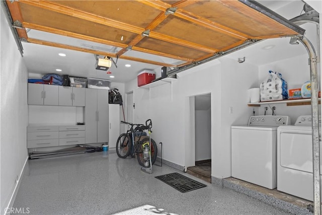 garage with a garage door opener and separate washer and dryer