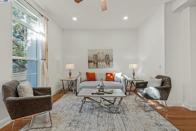 sitting room with ceiling fan and wood-type flooring