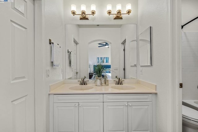 full bathroom with ceiling fan, vanity, toilet, and washtub / shower combination