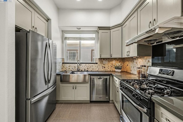 kitchen featuring sink, gray cabinetry, stainless steel appliances, tile patterned flooring, and backsplash