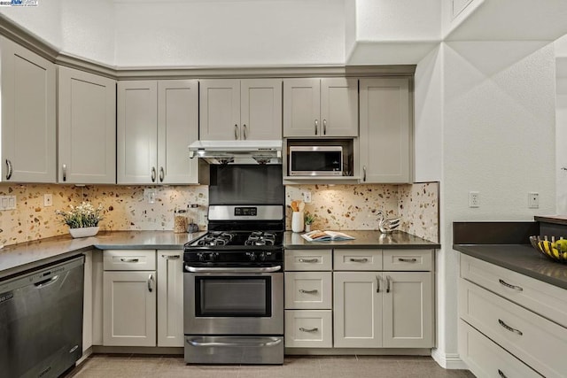 kitchen featuring stainless steel appliances, gray cabinetry, and decorative backsplash