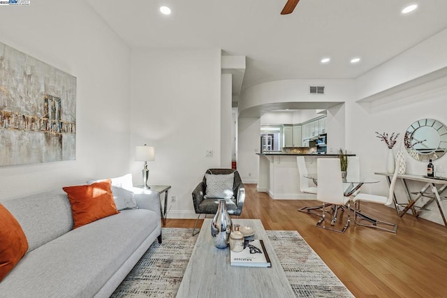 living room featuring light hardwood / wood-style floors and ceiling fan