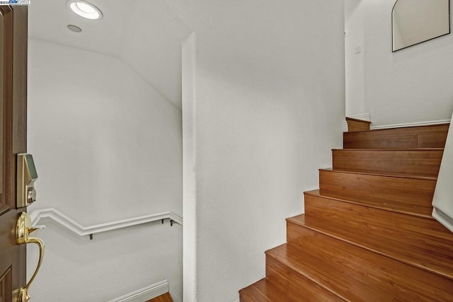 stairway featuring lofted ceiling