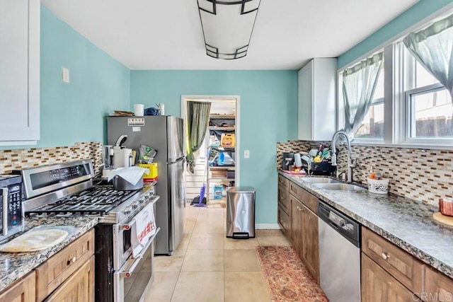 kitchen featuring light tile patterned flooring, stainless steel appliances, sink, and backsplash