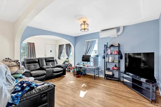 living room featuring hardwood / wood-style flooring, plenty of natural light, and a wall mounted AC