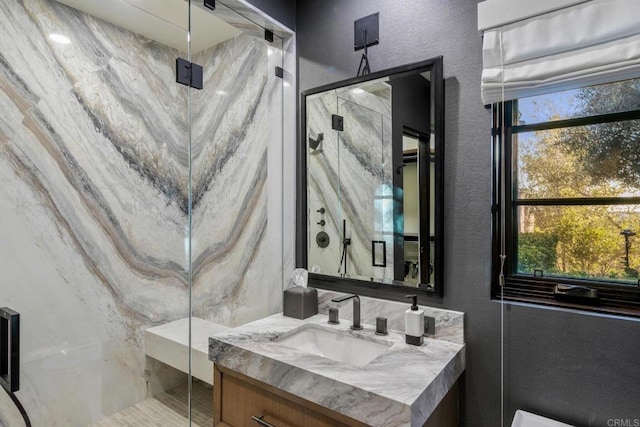 bathroom with walk in shower, a healthy amount of sunlight, and vanity