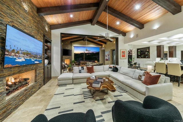 interior space with beamed ceiling, a stone fireplace, high vaulted ceiling, and wooden ceiling