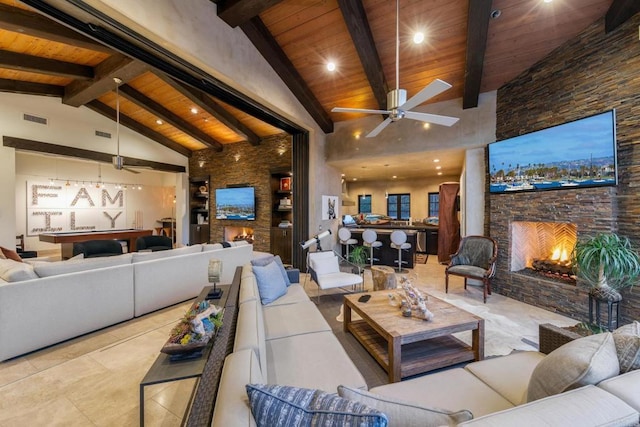 tiled living room featuring a fireplace, beam ceiling, and wooden ceiling