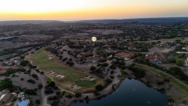 aerial view at dusk featuring a water view