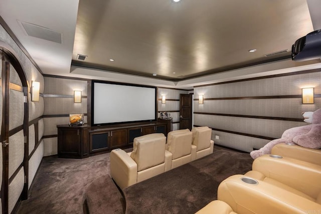 home theater with dark colored carpet and a tray ceiling