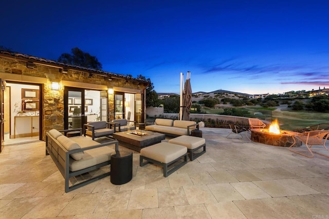 patio terrace at dusk featuring an outdoor living space with a fire pit