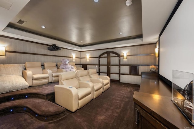 home theater featuring a raised ceiling and dark carpet