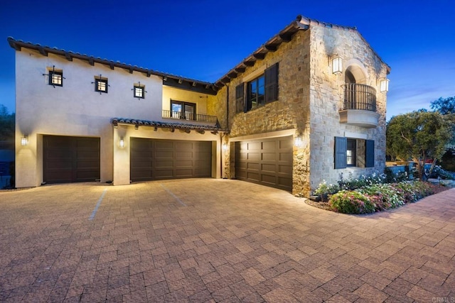 7795 Sendero Angelica, San Diego, CA 92127 - mediterranean / spanish-style house featuring a balcony, a garage, stone siding, decorative driveway, and stucco siding