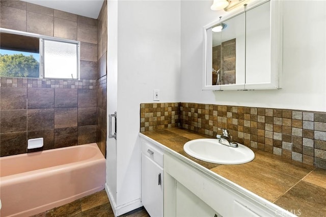 bathroom featuring tasteful backsplash, vanity, and tiled shower / bath combo