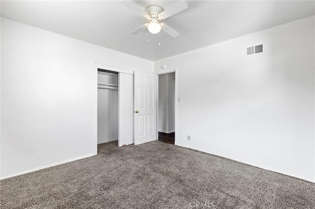 unfurnished bedroom featuring dark colored carpet, ceiling fan, and a closet