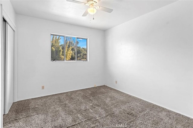 carpeted spare room with ceiling fan