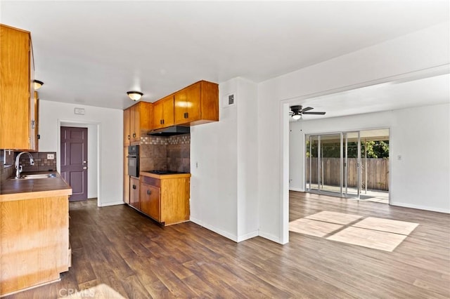 kitchen featuring sink, ceiling fan, backsplash, dark hardwood / wood-style floors, and black appliances