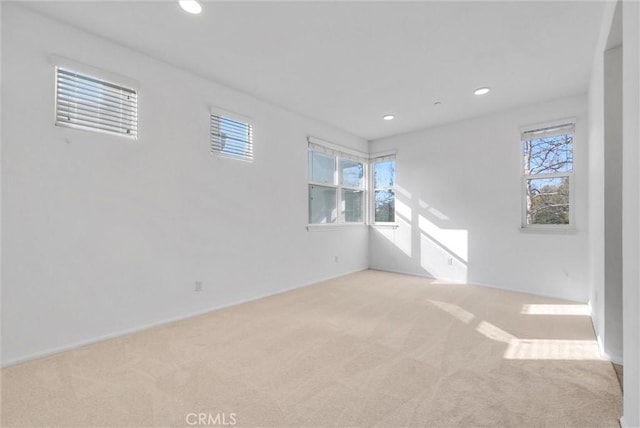 empty room featuring light colored carpet and a healthy amount of sunlight