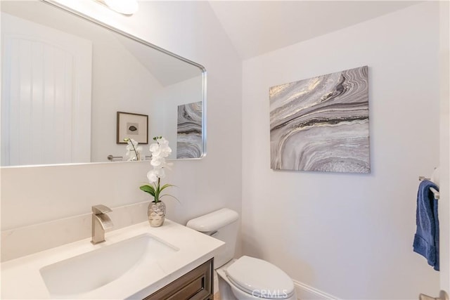 bathroom with vanity, vaulted ceiling, and toilet