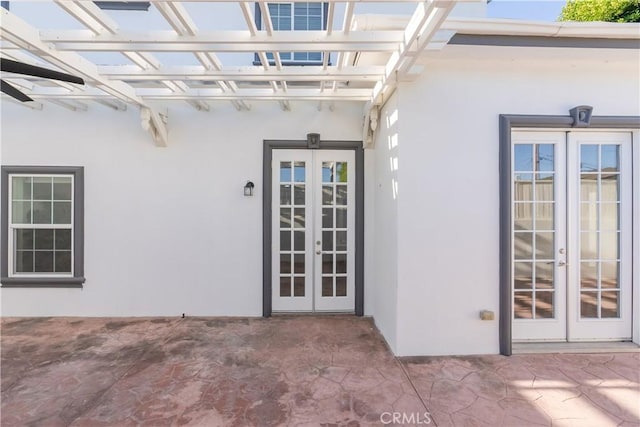 property entrance featuring a patio area and french doors