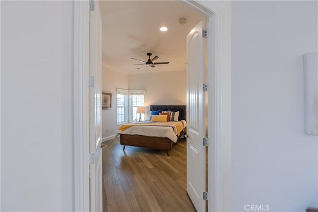 bedroom featuring ornamental molding and light hardwood / wood-style flooring