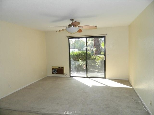 empty room with heating unit, light carpet, and ceiling fan