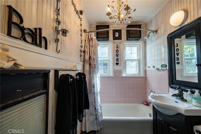 bathroom featuring vanity, a textured ceiling, and shower / tub combo with curtain