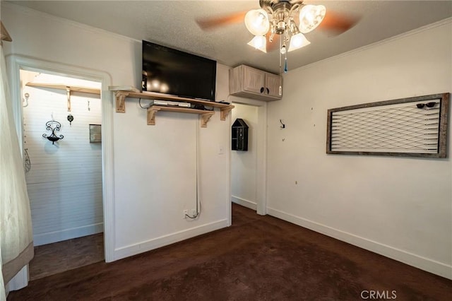 unfurnished bedroom with dark colored carpet, ornamental molding, a textured ceiling, and ceiling fan